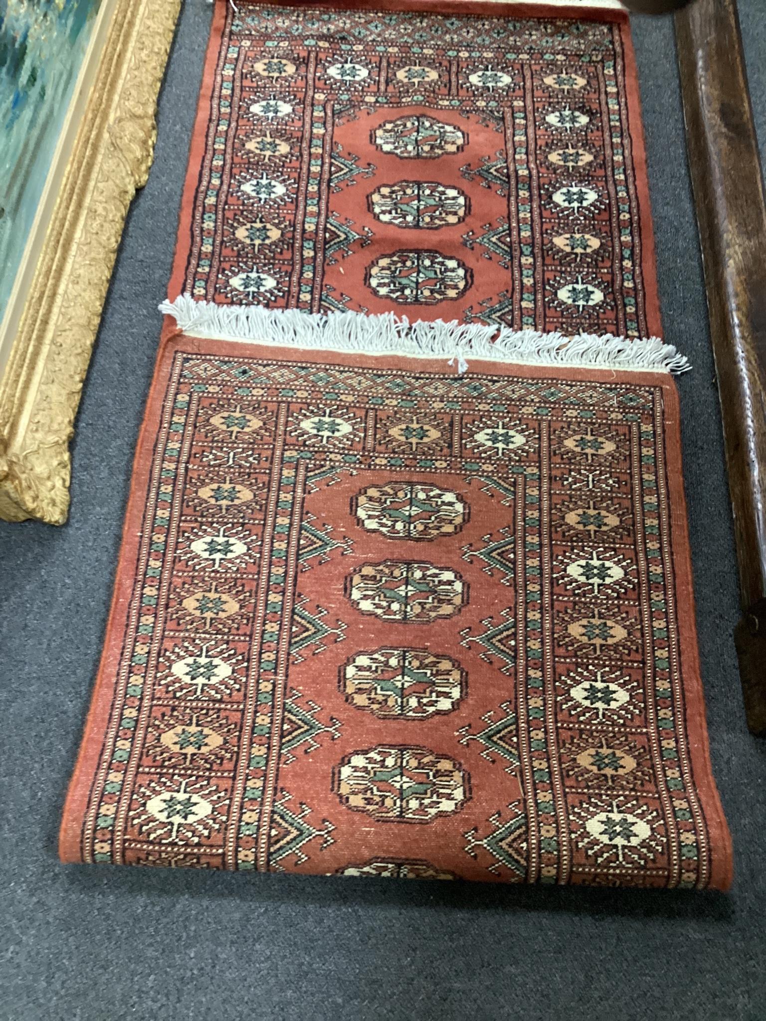 A Bokhara style red ground rug, 190 x 62cm